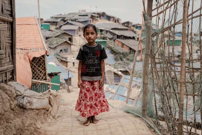 Asha stands in a a refugee camp in Bangladesh