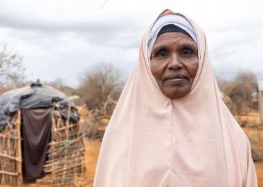 Fatuma standing in front of her home in Marsabit County, Kenya