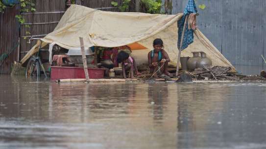 Girl sits by severe flooding in India, South Asia