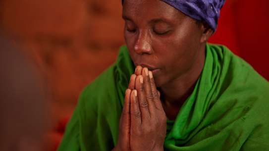 Woman praying in Burundi