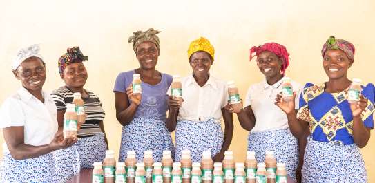 Eddina far left) and Janet (far right) with their Makande Womens Group and baobab juice