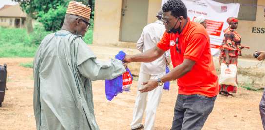 3695 - Christian Aid staff handing over a prepacked bag of non-food items to an excited recipient