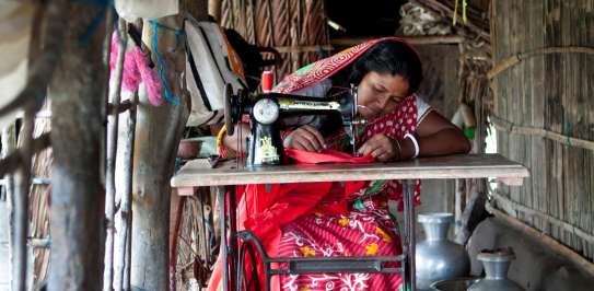 Ponchi Rani Mondol sits at her sewing machine at home in Bangladesh