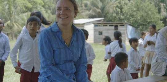 Eleri Davies is sitting with children at a school in Bolivia