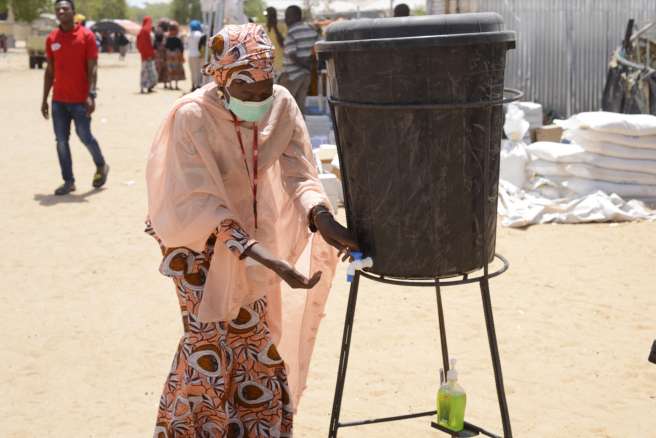 Bintu washes her hands in a displacement camp in Nigeria 