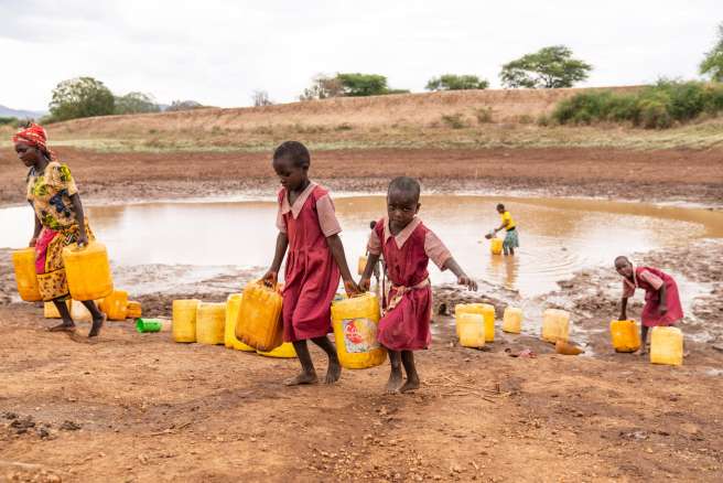 Children carrying water they collected from the Mikuyuni earth dam