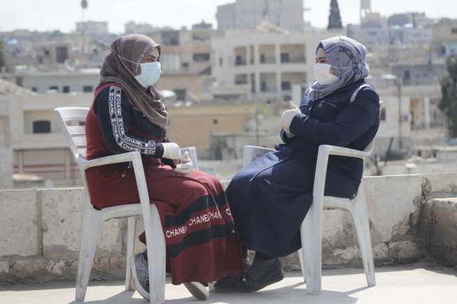 Aida (right), sits with her sister Ghada. Life skills training at her local centre has helped her rebuild her confidence