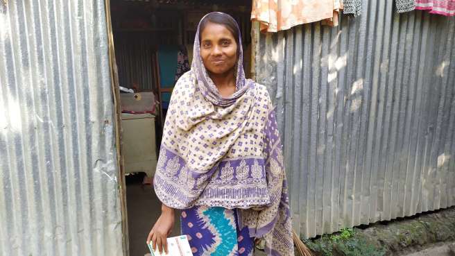 Morjina Begum standing outside her home in Basedpur village. 
