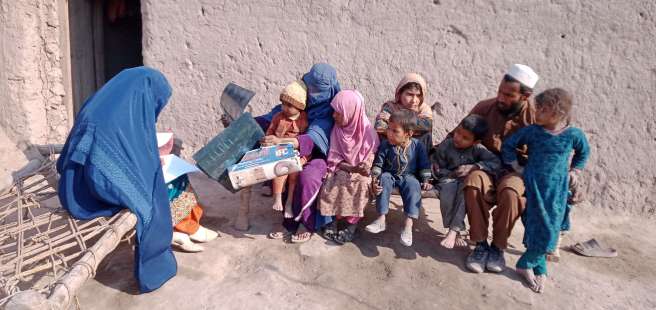 Sharifa sits with her family outside their home in Nangahar province, Eastern Afghanistan. 