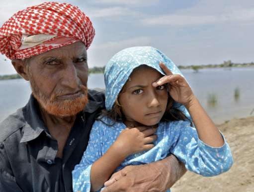 Elderly man with young girl with water behind them