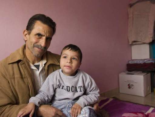 Six year-old Hammoudi sits with his grandfather, Mohammed 