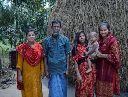  Kakoli Khatun stands in her courtyard with her family - her mother, father, and two siblings