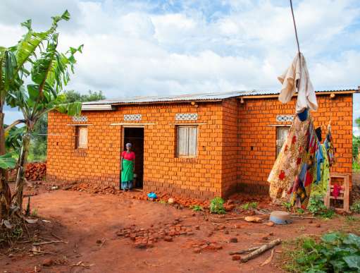 Woman outside built home in Burundi