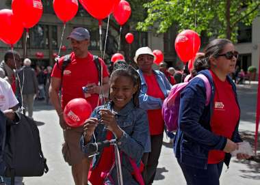 Girl holding Christian Aid balloons among a crowd of Christian Aid fundraisers