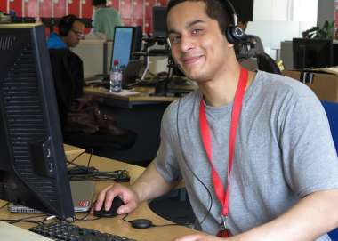 Christian Baeza, IT volunteer, sitting at a desk