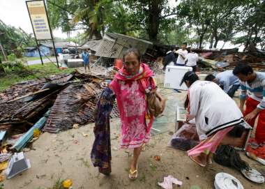 Woman walking amongst debris Indonesia tsunami