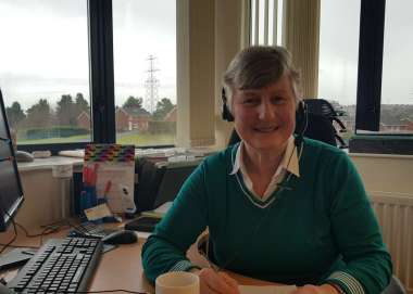 Suzanne Shepherd, a Christian Aid office volunteer Belfast, sits at desk