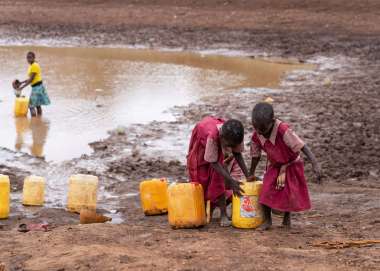 Children collecting water in buckets in Kitui, Kenya