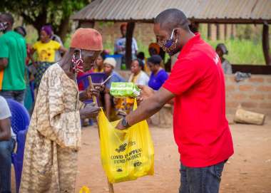 Tyonyar Ungon, 60, collecting his hygiene kit at an aid distribution funded by Christian Aid’s Covid appeal in Adagi community, Benue State, Nigeria, November 2020. He is partially disabled.