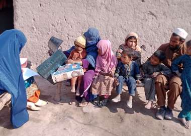 Sharifa sits with her family outside their home in Nangahar province, Eastern Afghanistan. 