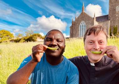 Men smiling with peas for Christian Aid Week 2023