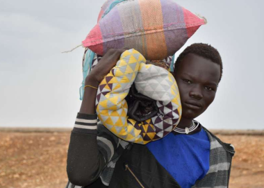 A young man arriving at the Joda border, in South Sudan, carrying his belongings on his shoulder