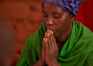 Woman praying in Burundi