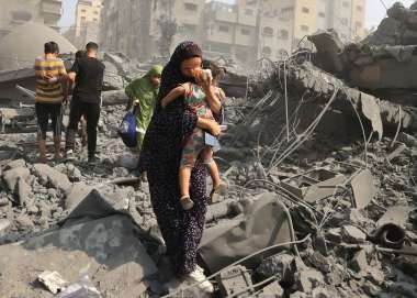 woman cradles child amongst rubble